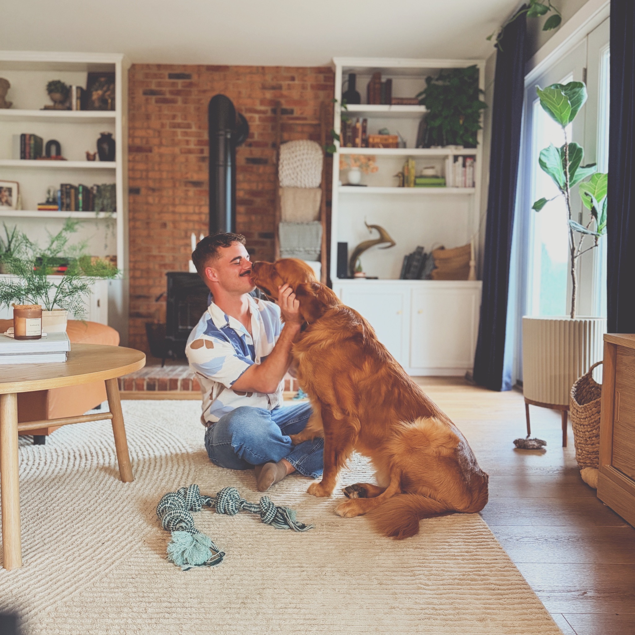 Matt sharing an affectionate moment with a golden retriever at home
